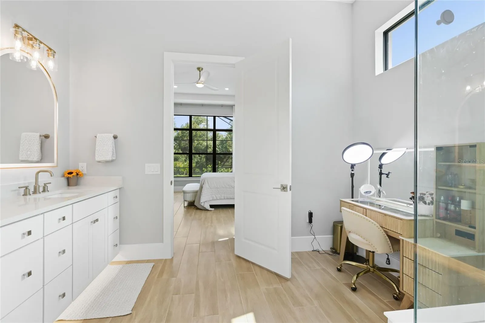 Primary Bathroom with walk in show with full glass enclosure, under lighting cabinetry, illuminating mirrors and expansive walk-in closet with custom shelving and cabinetry.