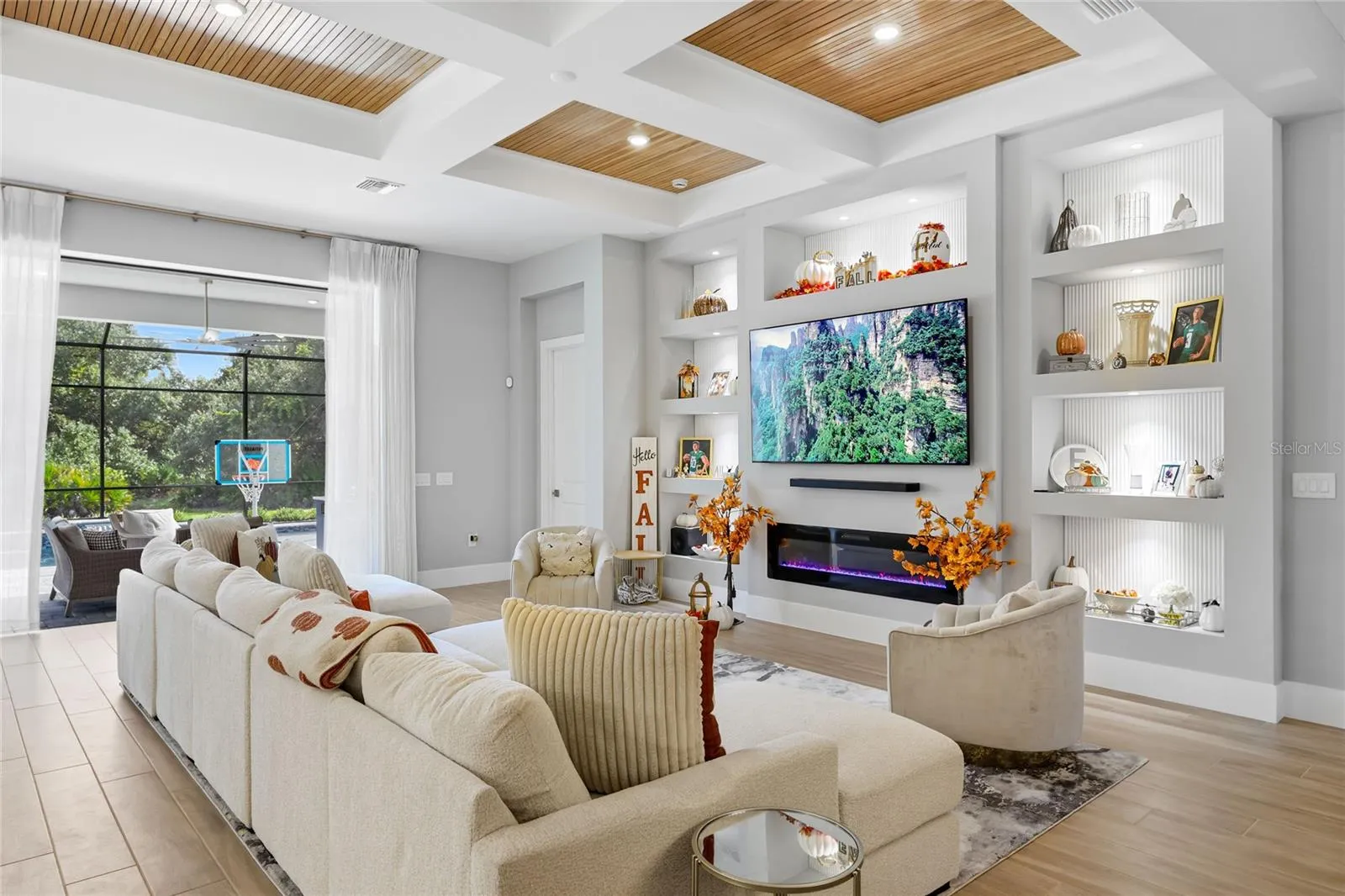 Custom built-in cabinetry with elegant display shelving and a striking fireplace creates a sophisticated focal point in the living room, blending timeless design with warmth and style.