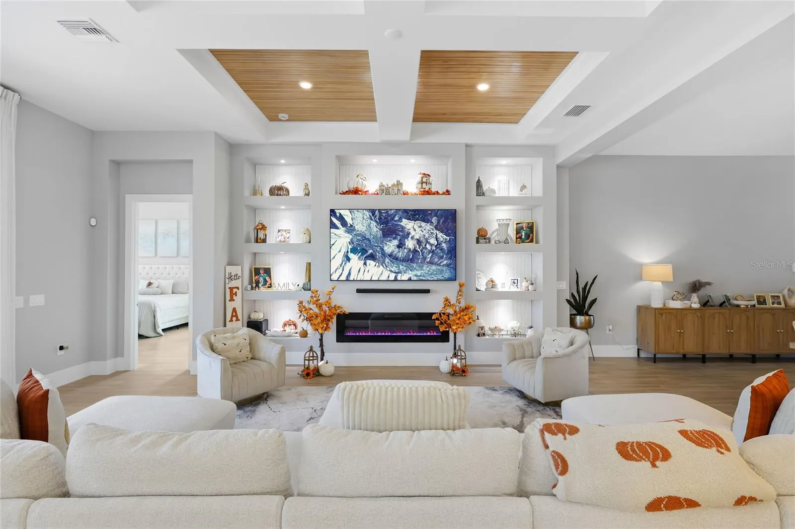 Custom built-in cabinetry with elegant display shelving and a striking fireplace creates a sophisticated focal point in the living room, blending timeless design with warmth and style.