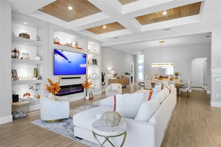 Custom built-in cabinetry with elegant display shelving and a striking fireplace creates a sophisticated focal point in the living room, blending timeless design with warmth and style.