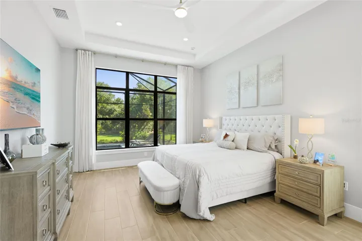 Primary Bedroom Ensuite with expansive windows overlooking the Lanai and custom pool.