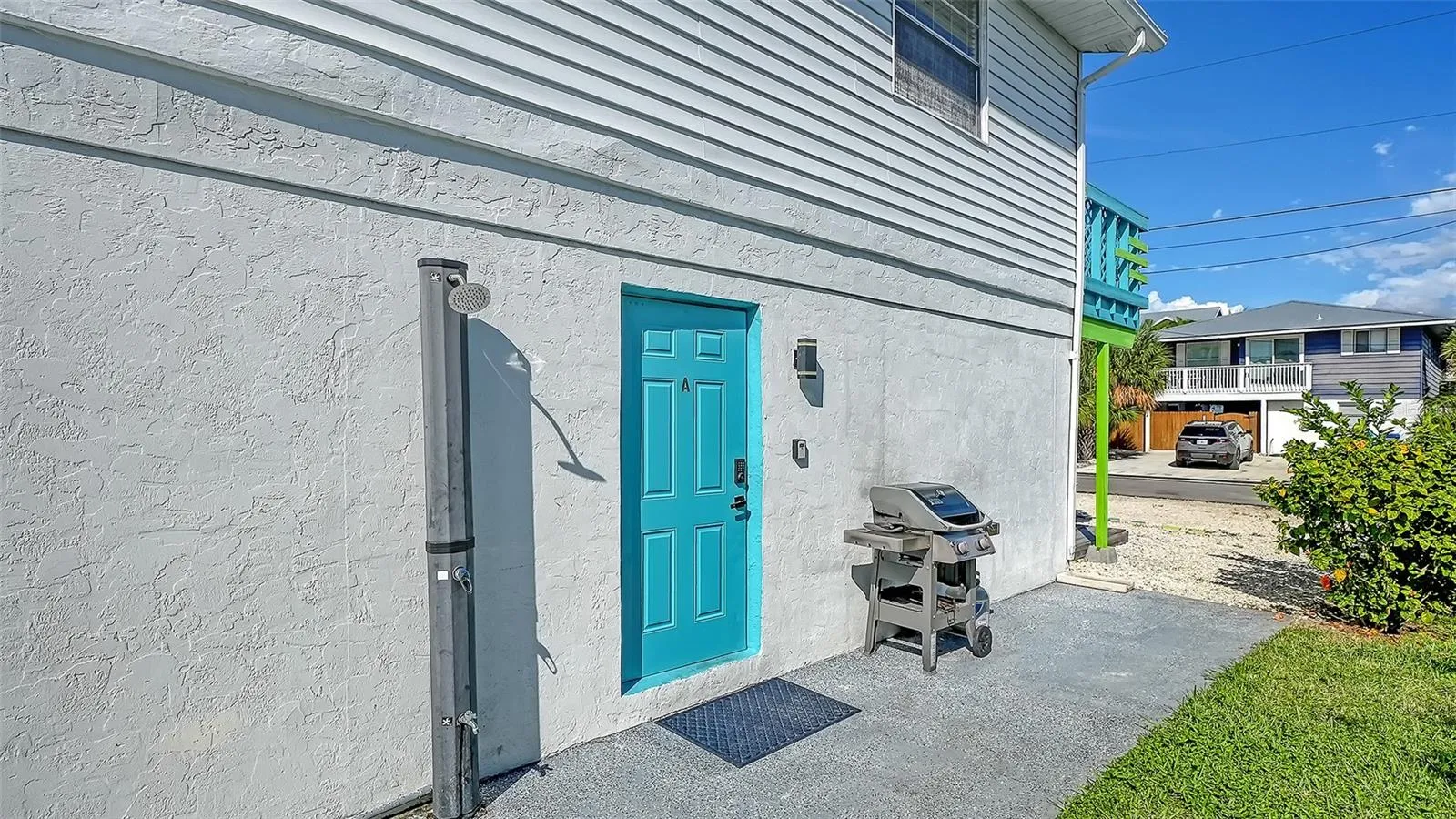 Both units have left side entrances. Blue door, Unit A. Both units have a propane grill. Common exterior shower that both units share.
