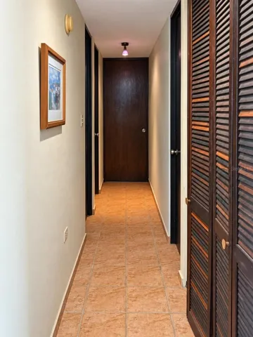 Hallway with a linen closet, leading to the bedrooms and bathrooms.