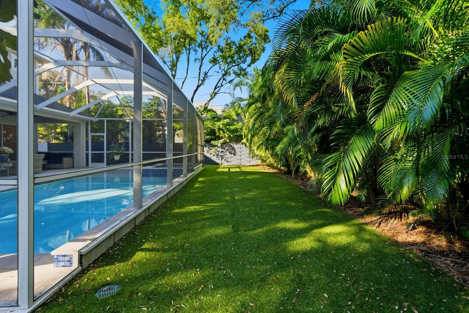 side turf yard beyond rear of pool