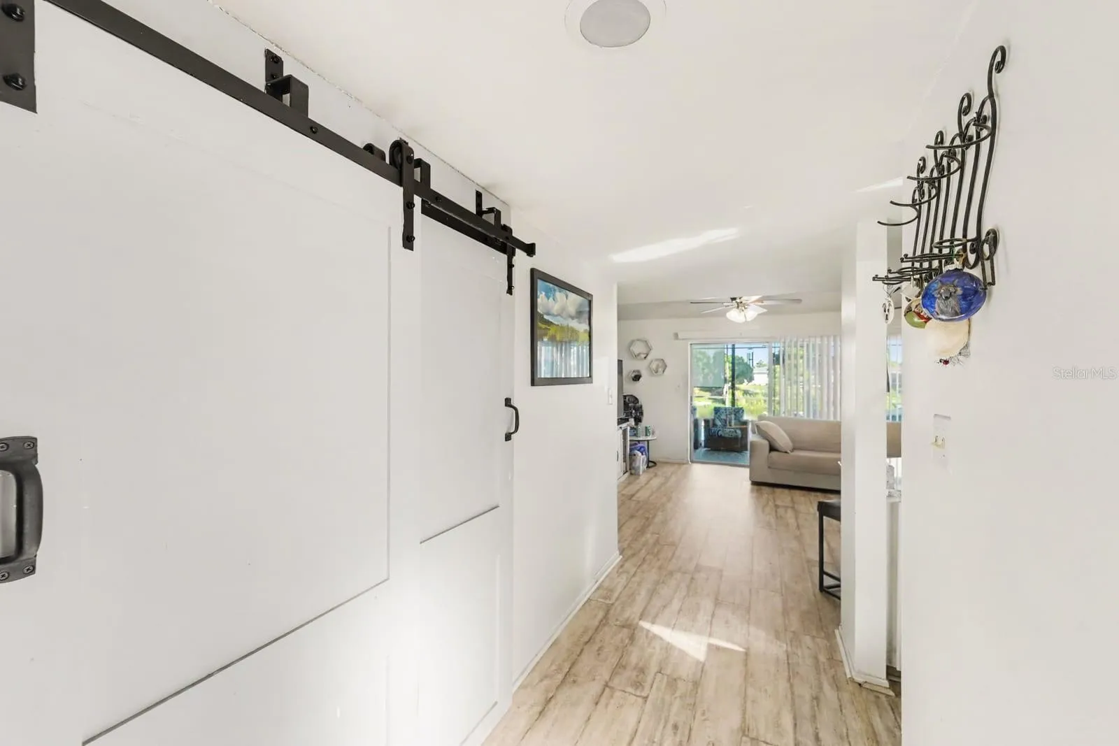Bright entry hallway with barn door and wood-look flooring