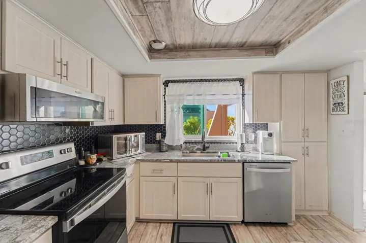 Bright Kitchen With Cream Cabinetry, Black Hexagon Tile & Window Views