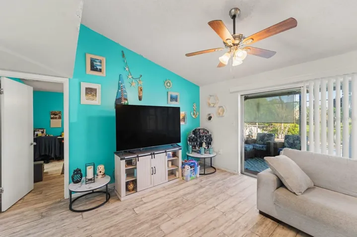 Bright media room with turquoise feature wall and sliding patio access