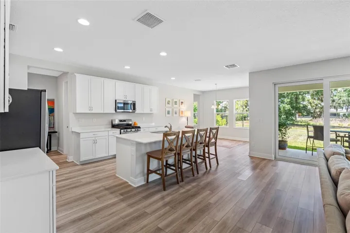 Bright kitchen and cafe with tree-lined backyard views