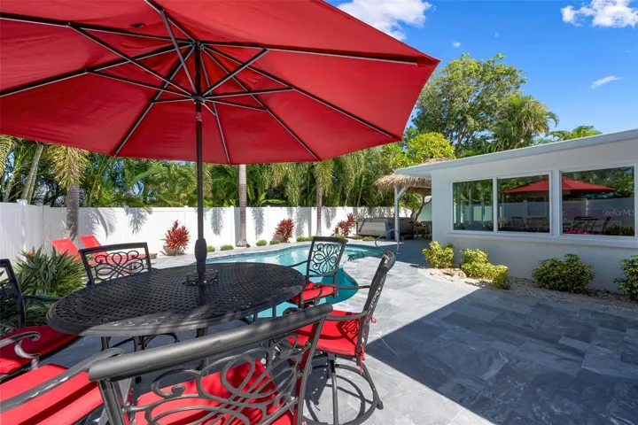 Pavered outdoor pool patio with heated saltwater pool and hot tub