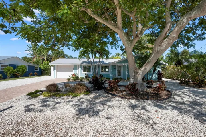 Front of home with beautiful poinciana tree
