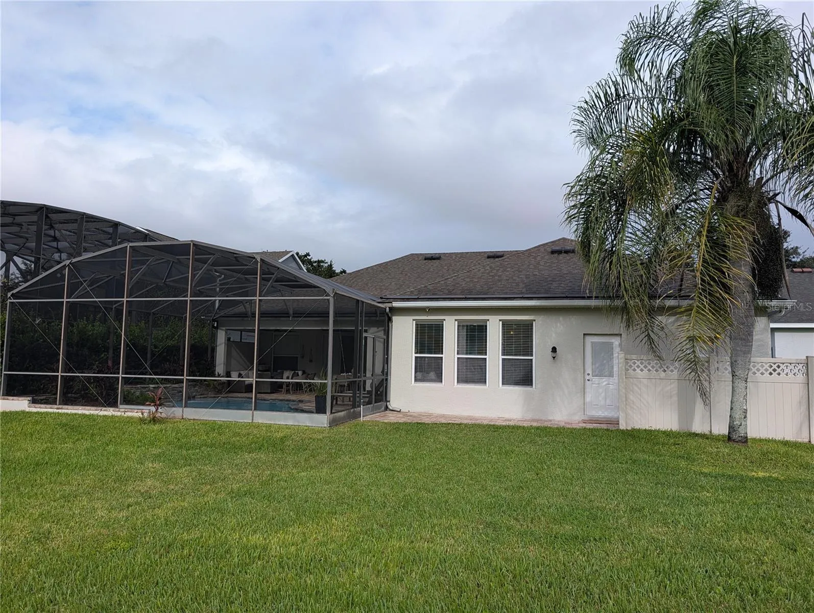 back ard with screened in lanai & pool