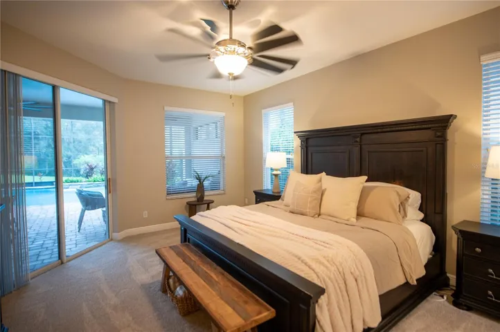 primary bedroom with door to lanai & pool