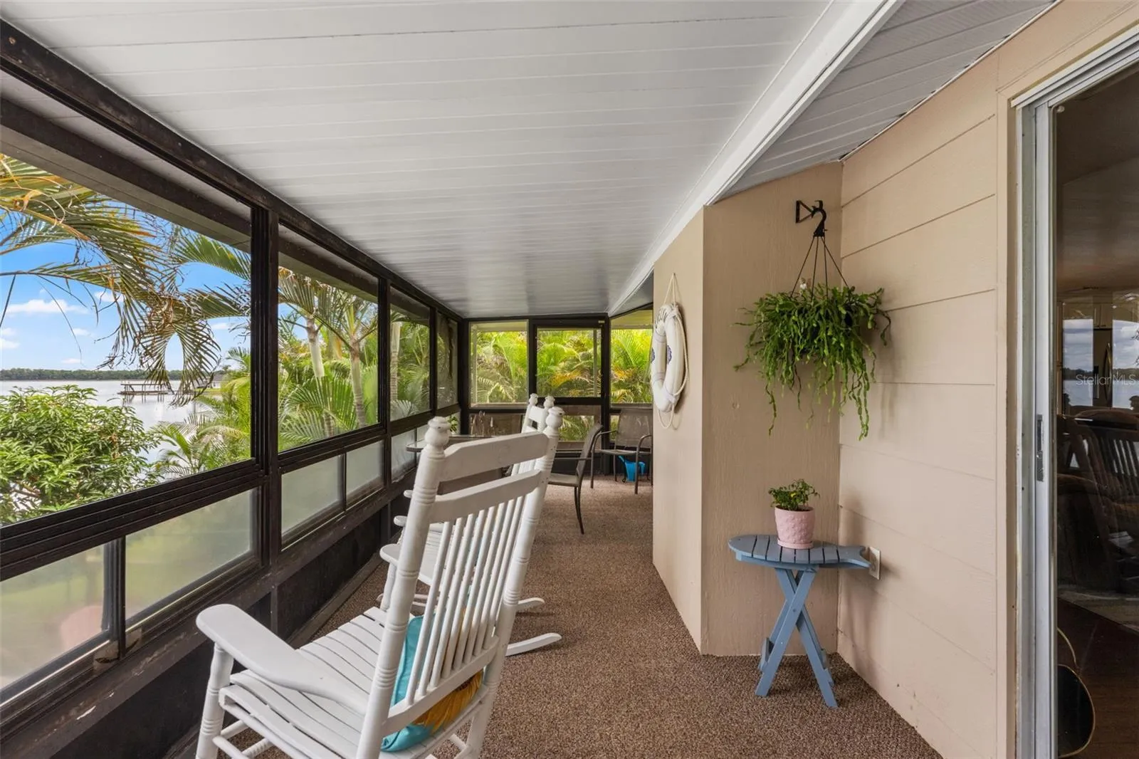Water views, tropical landscaping, and a comfortable rocking chair create the perfect setting to unwind. This elevated screened porch offers a wonderful vantage point for watching boats on the water or simply enjoying the peaceful surroundings.