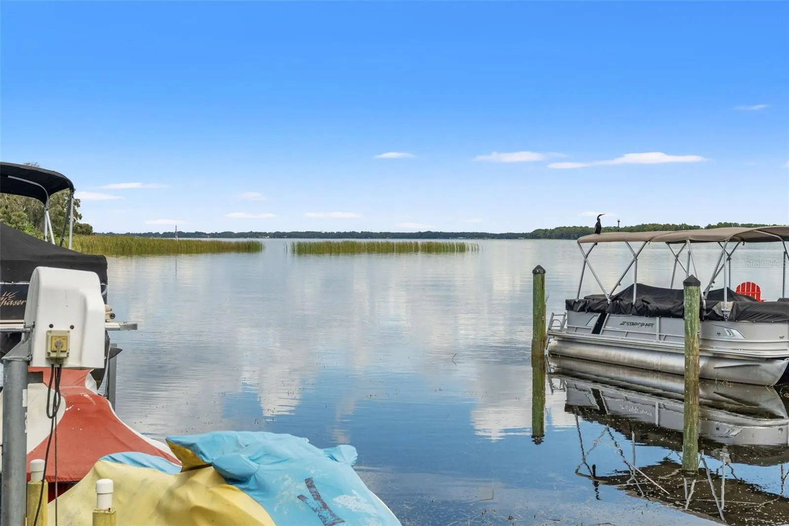 Wide-open water, peaceful surroundings, and beautiful Florida skies. Enjoy expansive lake views from the dock, with natural shoreline vegetation and distant tree-lined banks creating a scenic backdrop. A wonderful setting for boating, fishing, or simply appreciating the waterfront.
