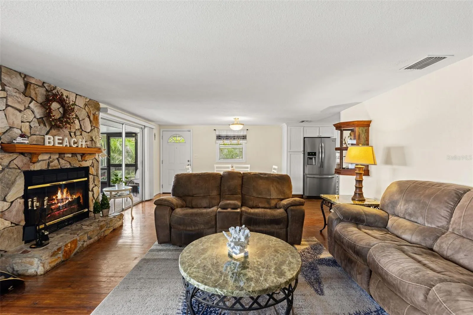 This is what waterfront living is all about! Sliding glass doors frame views of the screened porch, where a rocking chair invites you to sit back and enjoy the peaceful water, passing boats, and tropical surroundings.