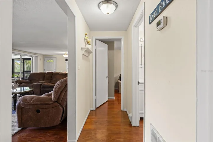 Wood flooring continues through the hallway, connecting the bedrooms and bathroom to the main living area. The convenient layout keeps everything within easy reach on the upper level.