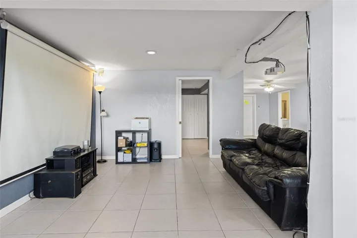 Bring the movie theater experience home with this lower-level entertainment space featuring a large projection screen and ceiling-mounted projector. The room offers space for comfortable seating and entertainment equipment, creating an inviting setting for movies, sports, and gatherings.