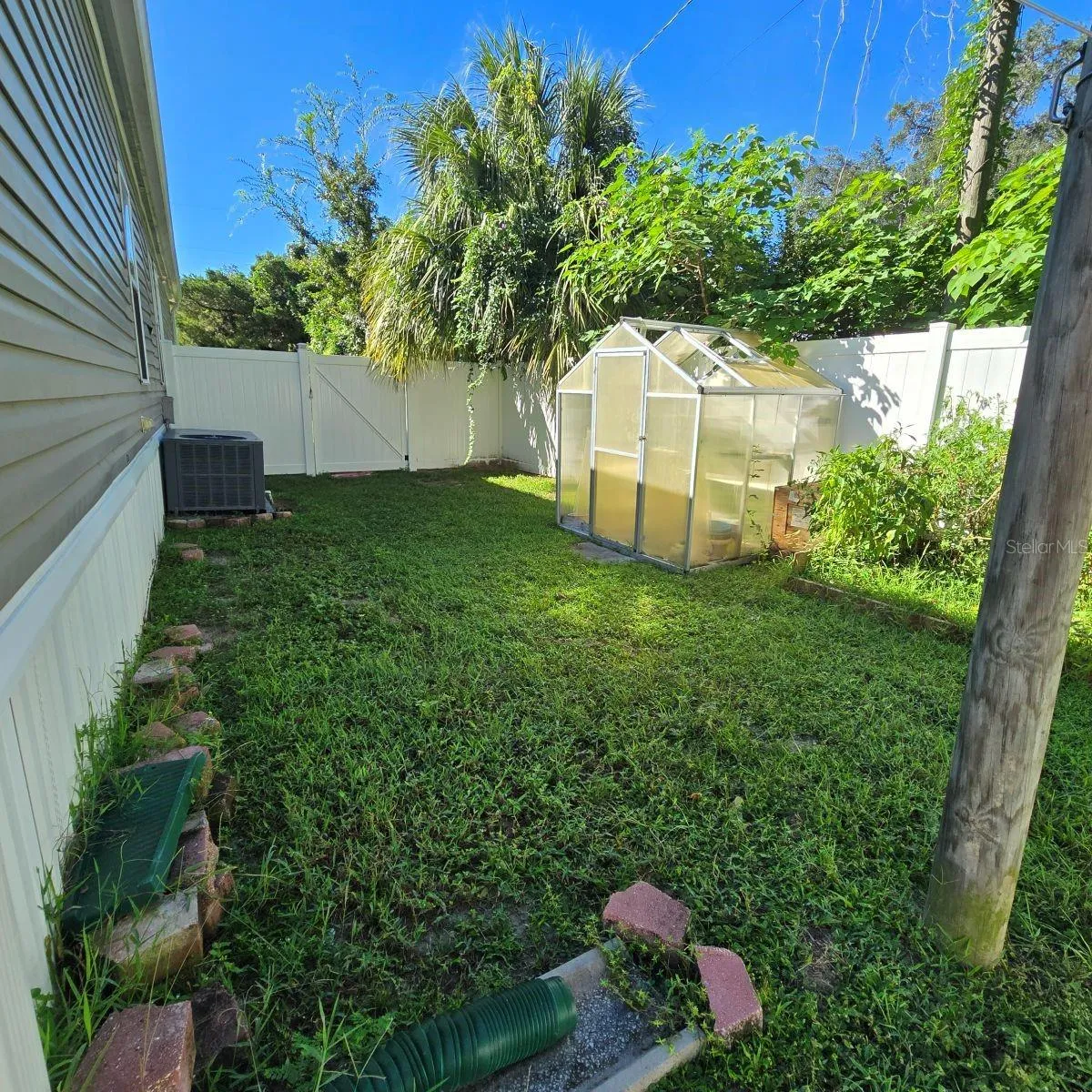 left side of property with green house