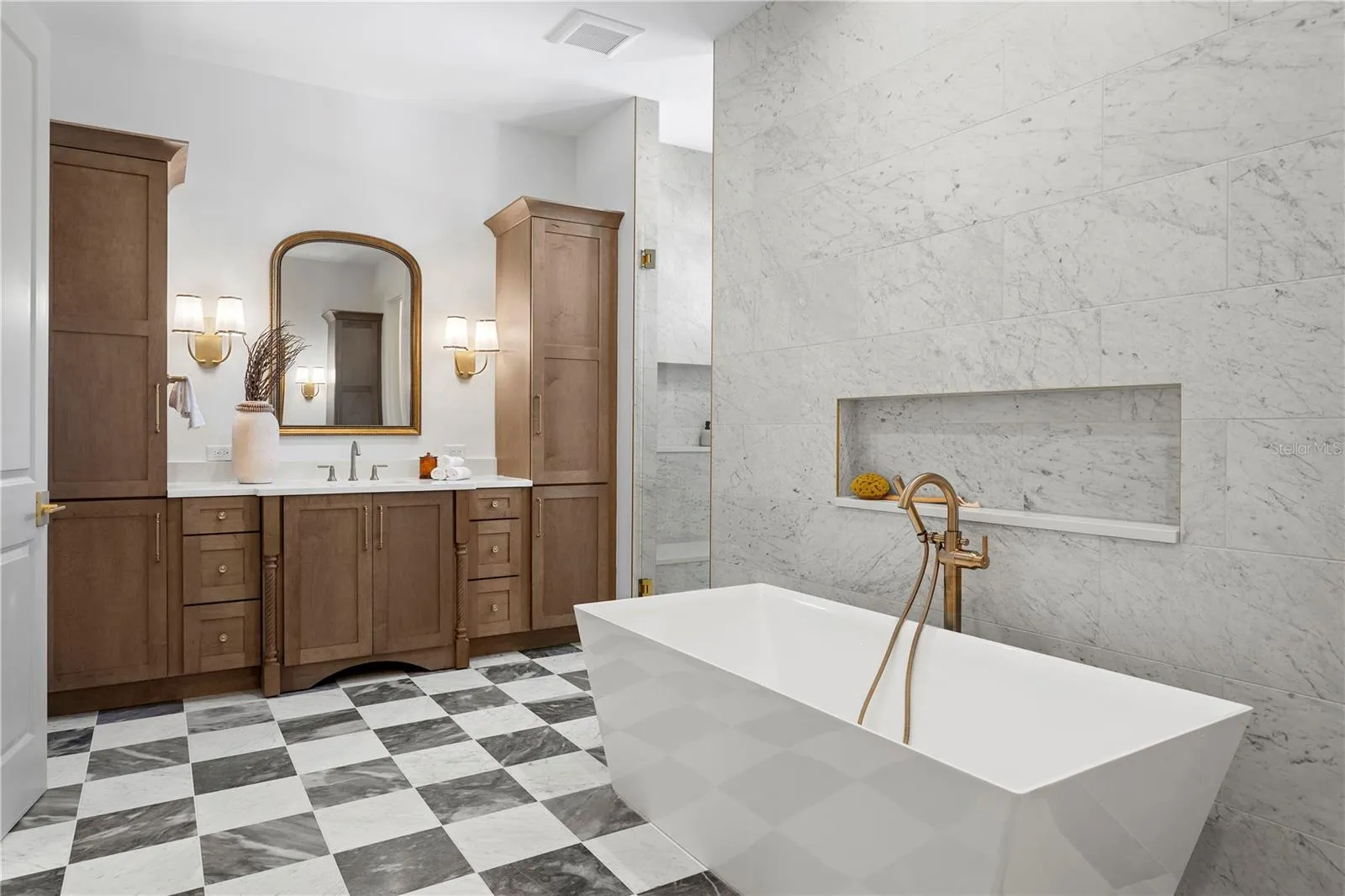 Primary bath with marble floors, soaking tub and large walk in shower