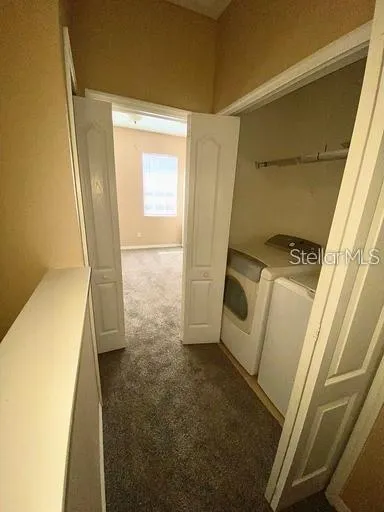 Looking at the laundry area and other primary bedroom from the loft