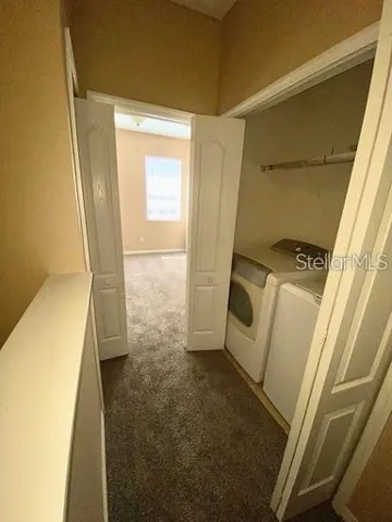 Looking at the laundry area and other primary bedroom from the loft