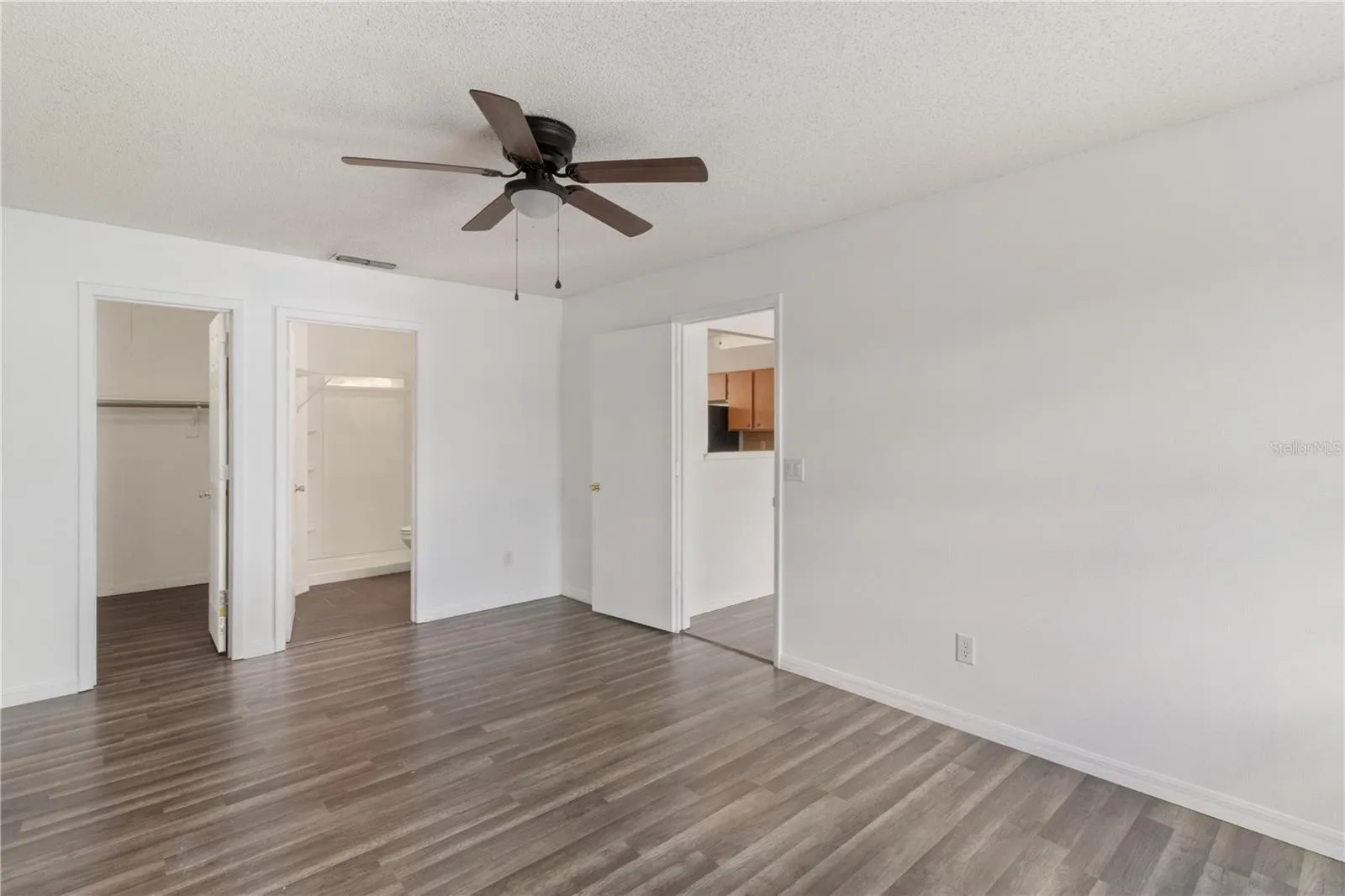 Primary Bedroom with View To Living Room, Bath, and Master Closet