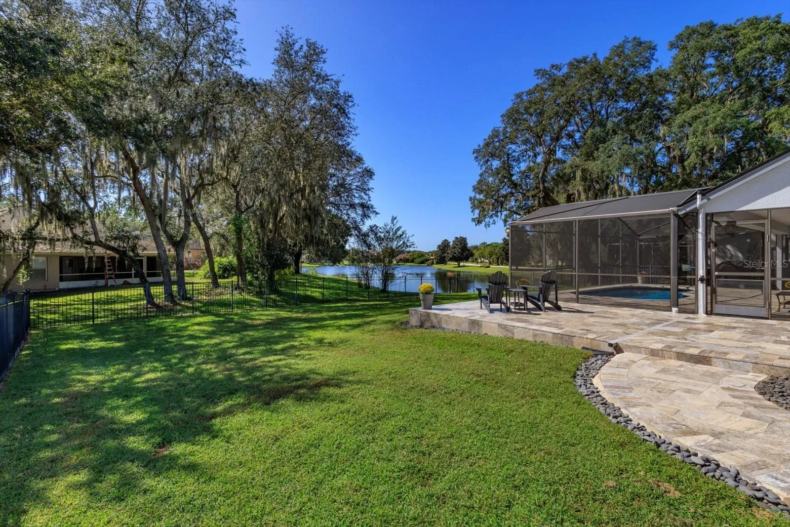 Spacious side yard with travertine patio and walkway to front