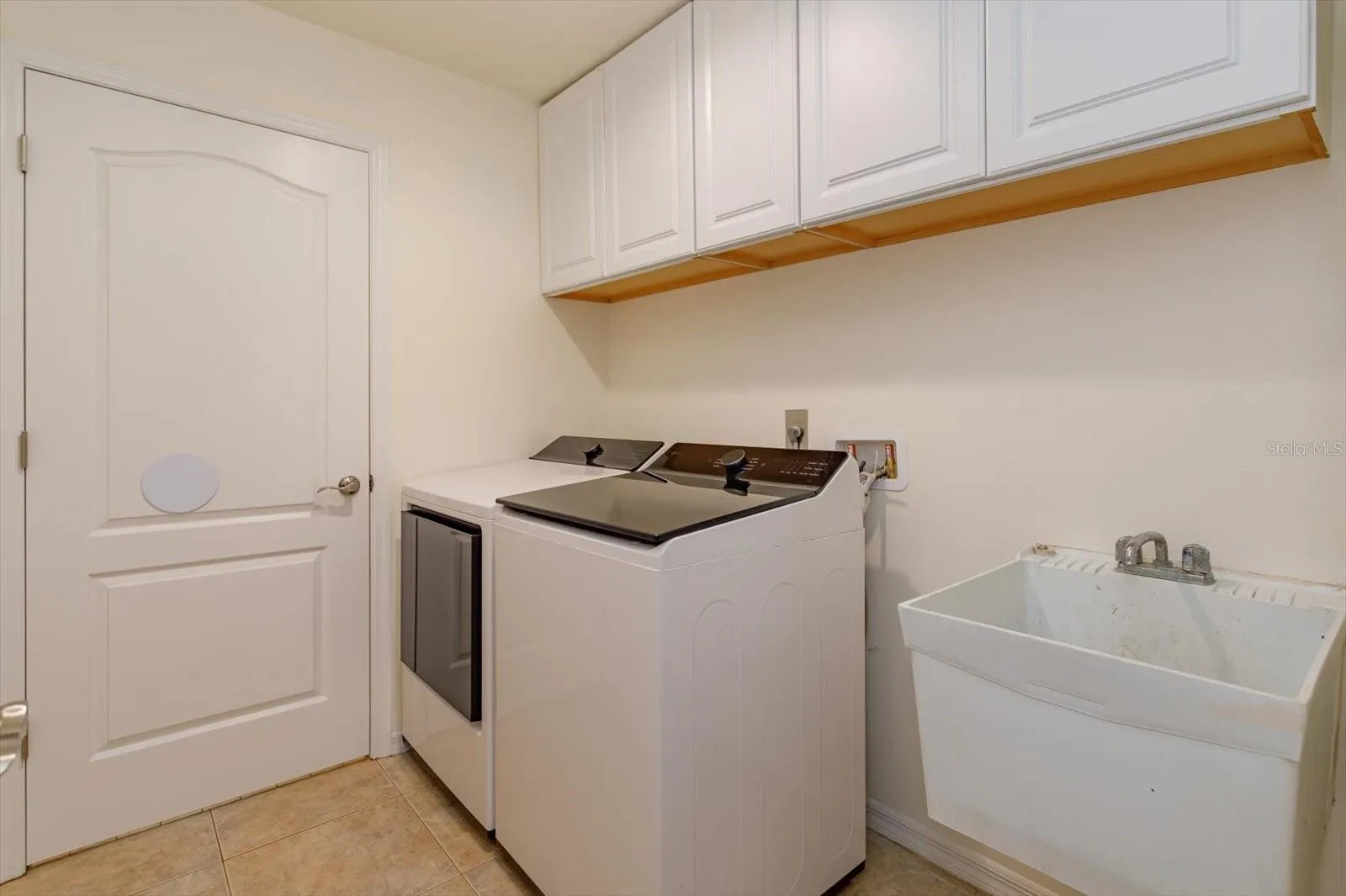 Laundry room with built in cabinets and sink