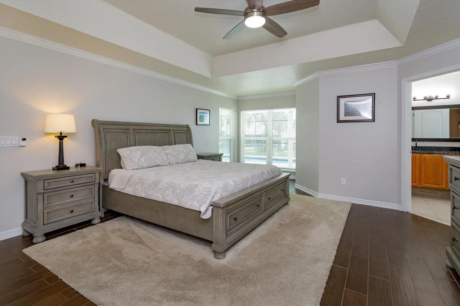 Freshly painted primary bedroom with sitting area and wood look tile