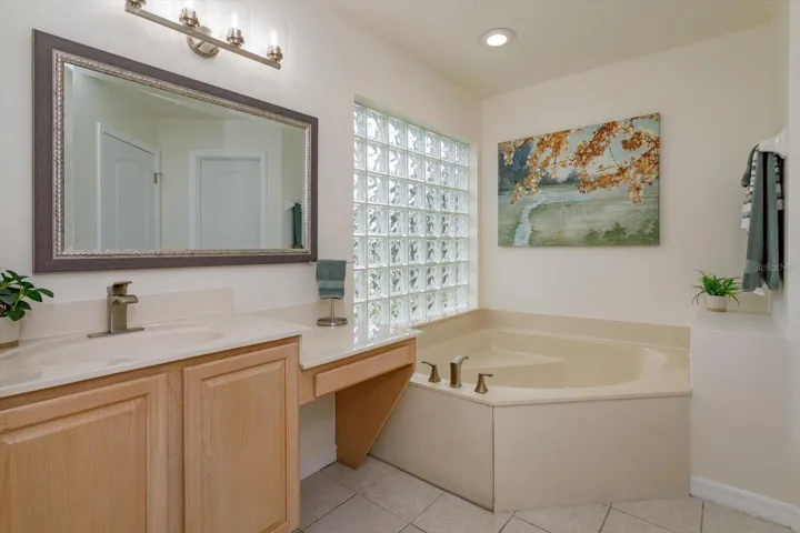 Her primary bathroom features corner tub, knee space and private water closet