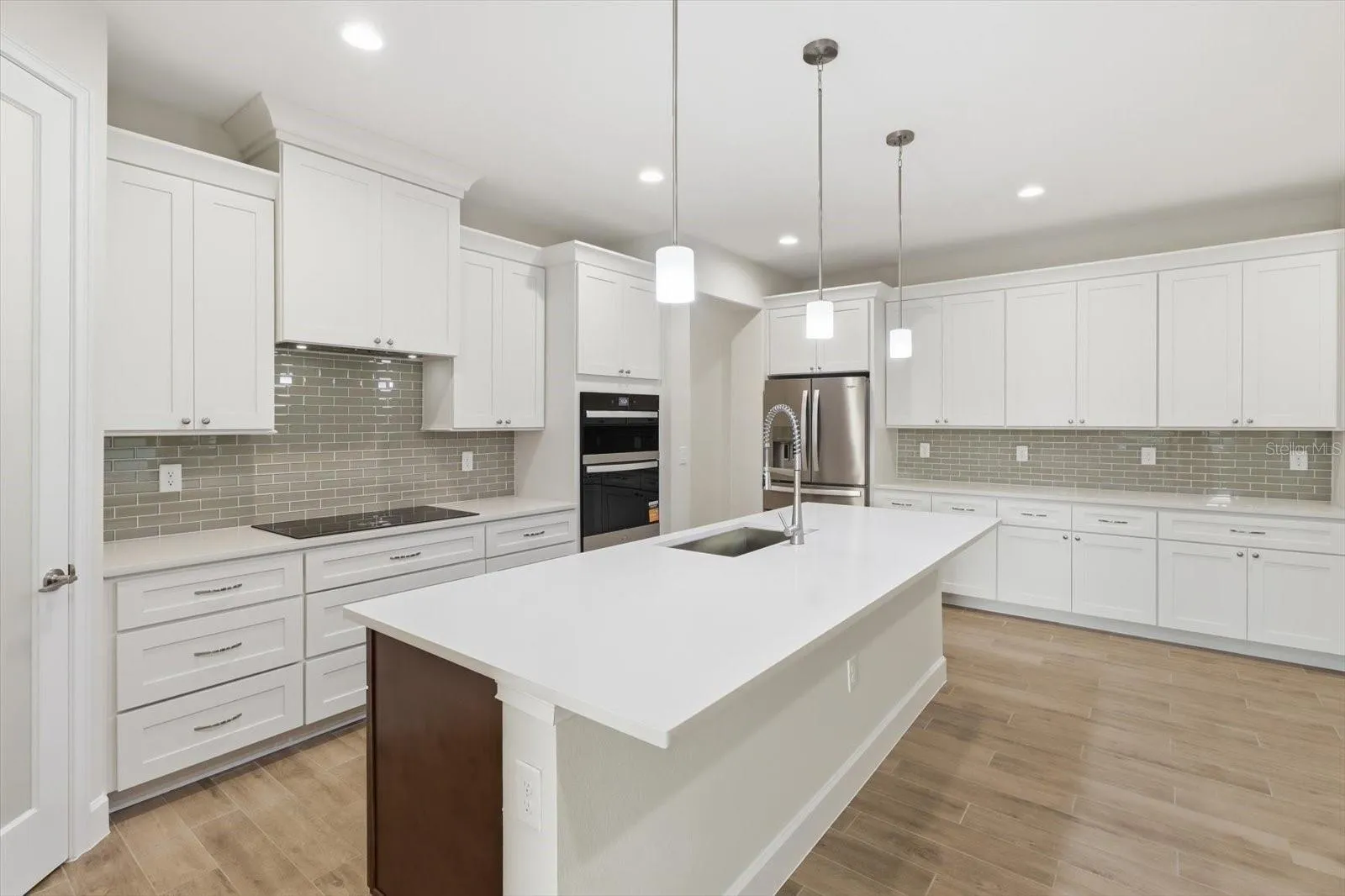The chefs kitchen features an oversized quartz island, walk in pantry, crown molding and upgraded 4 door refridgerator.