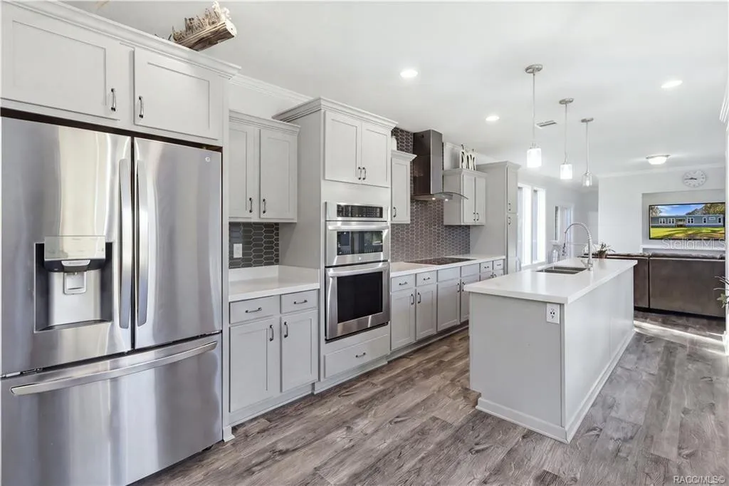 STYLE MEETS FUNCTION! The thoughtfully designed kitchen features GRAY CABINETRY, a DOUBLE-BASIN SINK, sleek spring-style faucet &amp; large windows overlooking the beautiful outdoors.