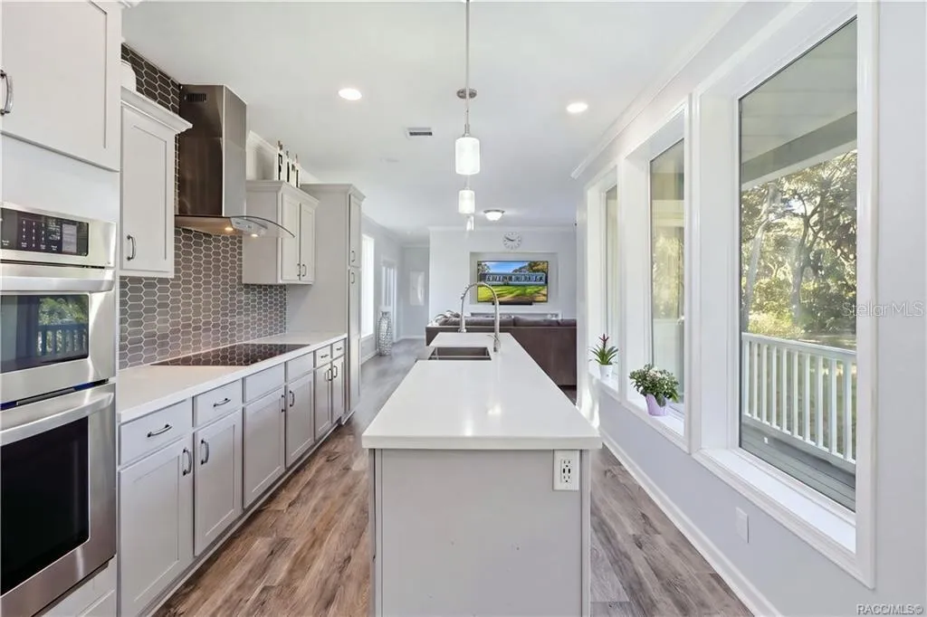 THE KITCHEN IS THE SHOWSTOPPER! Beautiful GRAY CABINETRY, expansive countertops, a generous CENTER ISLAND, stainless steel appliances &amp; pendant lighting create an impressive gathering space.
