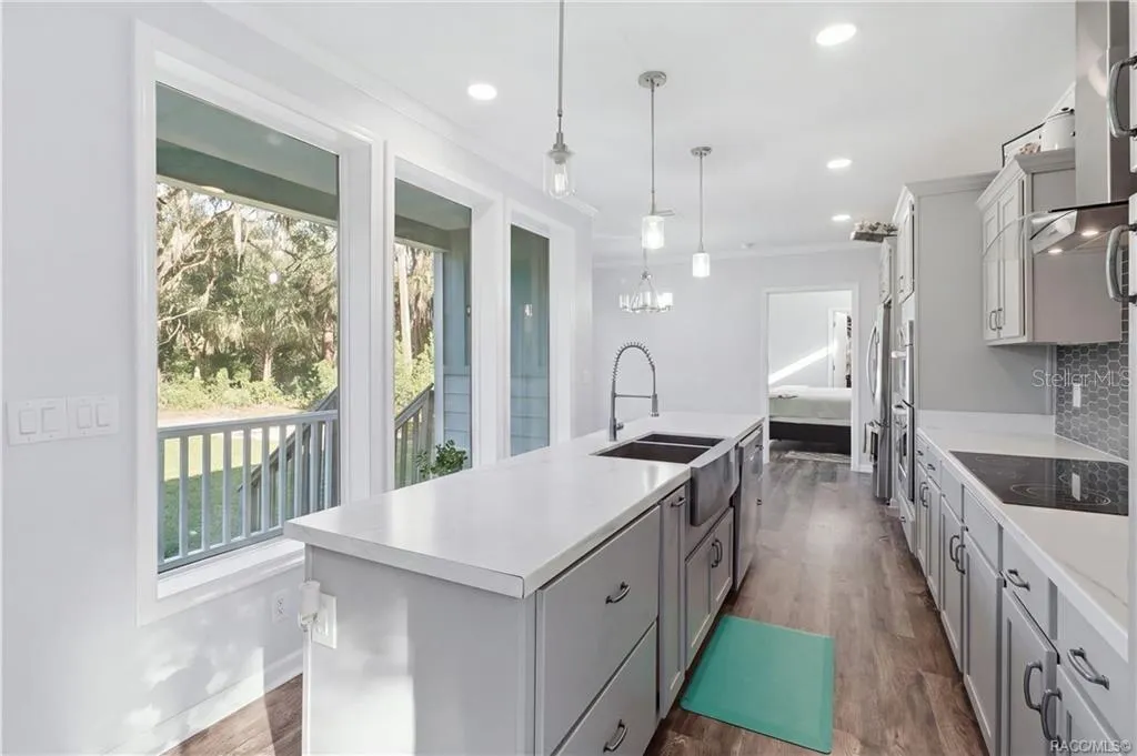 A KITCHEN W/A VIEW! The impressive island offers generous workspace, while large windows bring in natural light &amp; showcase the surrounding greenery.
