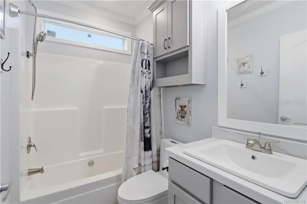 STYLE &amp; EVERYDAY CONVENIENCE! The SECOND FULL BATHROOM features a GRAY VANITY, framed mirror, additional wall cabinetry &amp; a TUB/SHOWER COMBINATION.