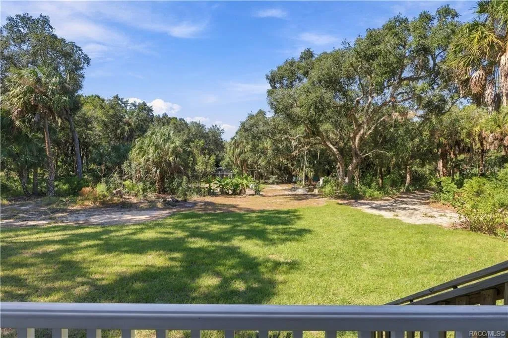 NATURE RIGHT OUTSIDE YOUR DOOR! Enjoy views of the expansive lawn, mature trees &amp; Florida palms from the comfort of your front porch.