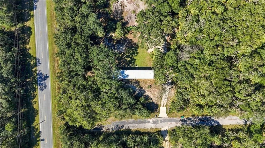 ROOM TO ENJOY THE OUTDOORS! This overhead aerial view highlights the home's setting among mature trees, open yard space &amp; surrounding greenery.