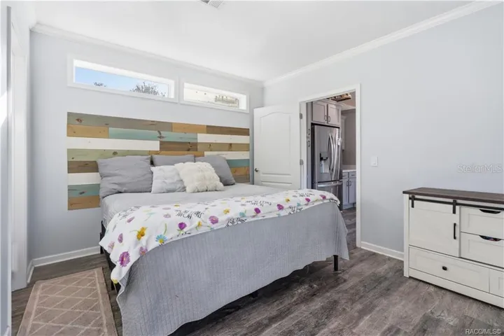 YOUR OWN COMFORTABLE RETREAT! The PRIMARY BEDROOM features beautiful natural light, neutral finishes, LUXURY VINYL PLANK FLOORING &amp; a distinctive wood-accent headboard.