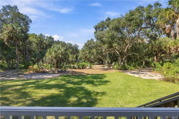 NATURE RIGHT OUTSIDE YOUR DOOR! Enjoy views of the expansive lawn, mature trees &amp; Florida palms from the comfort of your front porch.