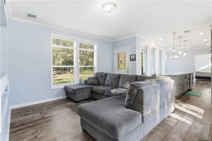 RELAX &amp; MAKE YOURSELF COMFORTABLE! The spacious LIVING ROOM features attractive flooring, abundant natural light &amp; an open connection to the kitchen.
