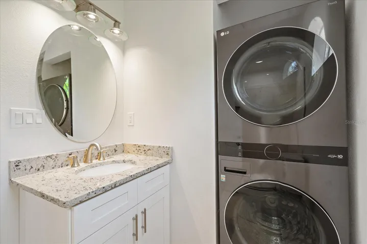 Bathroom with stackable washer &amp; dryer &amp; walk-in shower