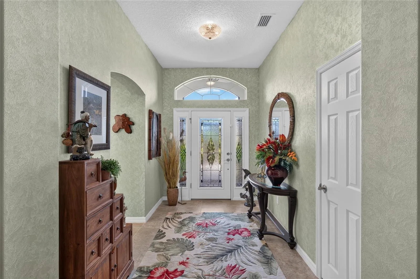 LEADED GLASS FRONT DOOR WITH DOUBLE SIDE LIGHTS AND TRANSOM WINDOWS.