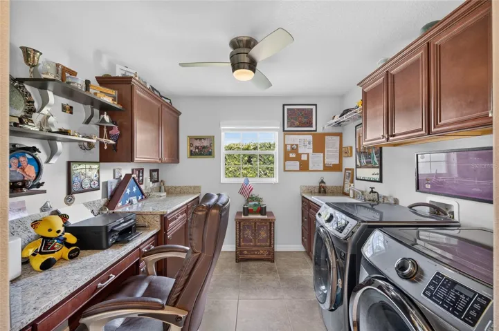 Laundry with sink, cabinets and built-in desk.
