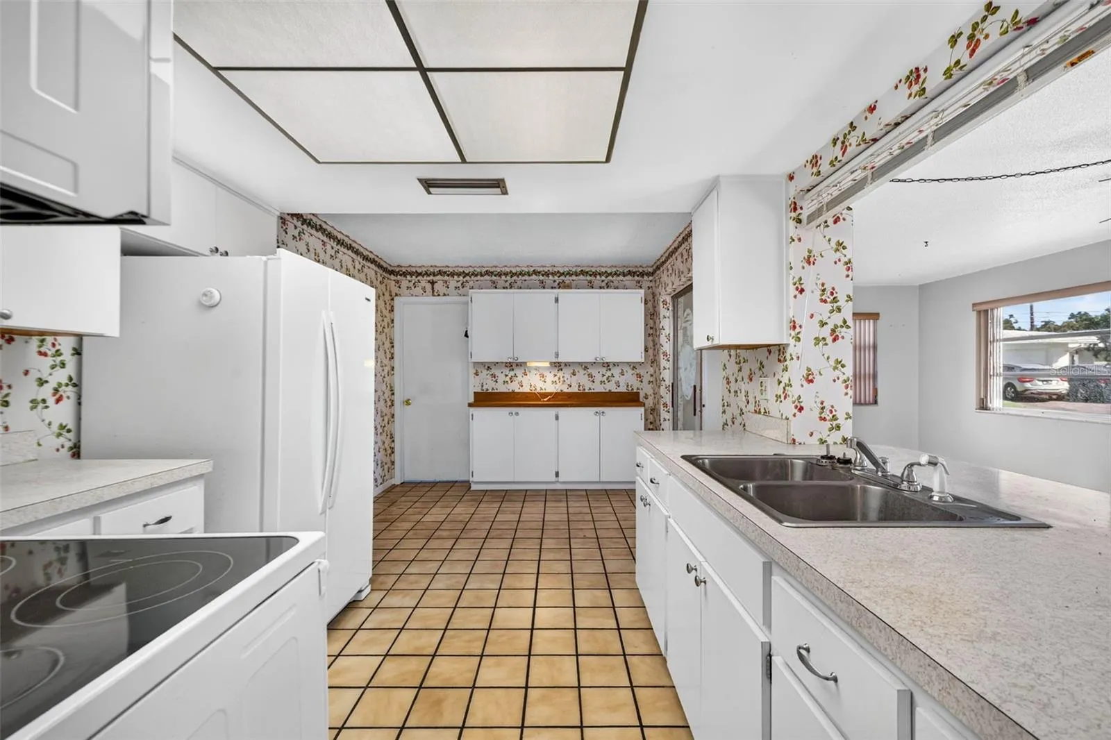 Huge kitchen with a convenient pass-through window that connects directly into the sunlit Florida room