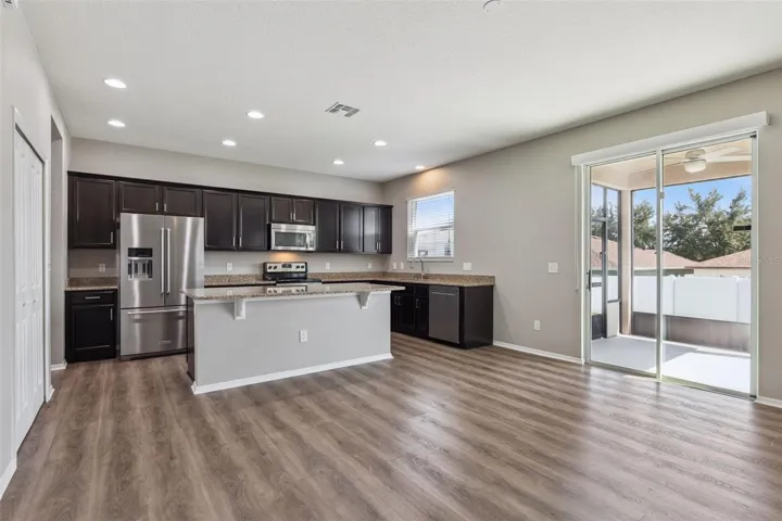 Gourmet kitchen with breakfast bar overlooking family room & screened covered lanai