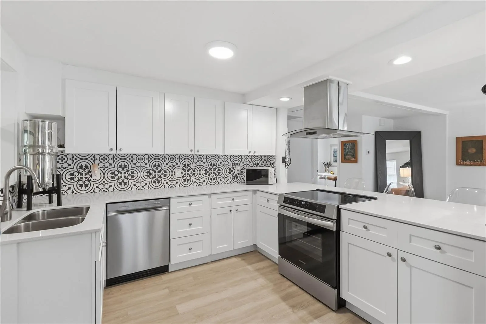 The stunning kitchen with quartz counters and stainless steel appliances including an induction stove with convection oven that is 3 months old.