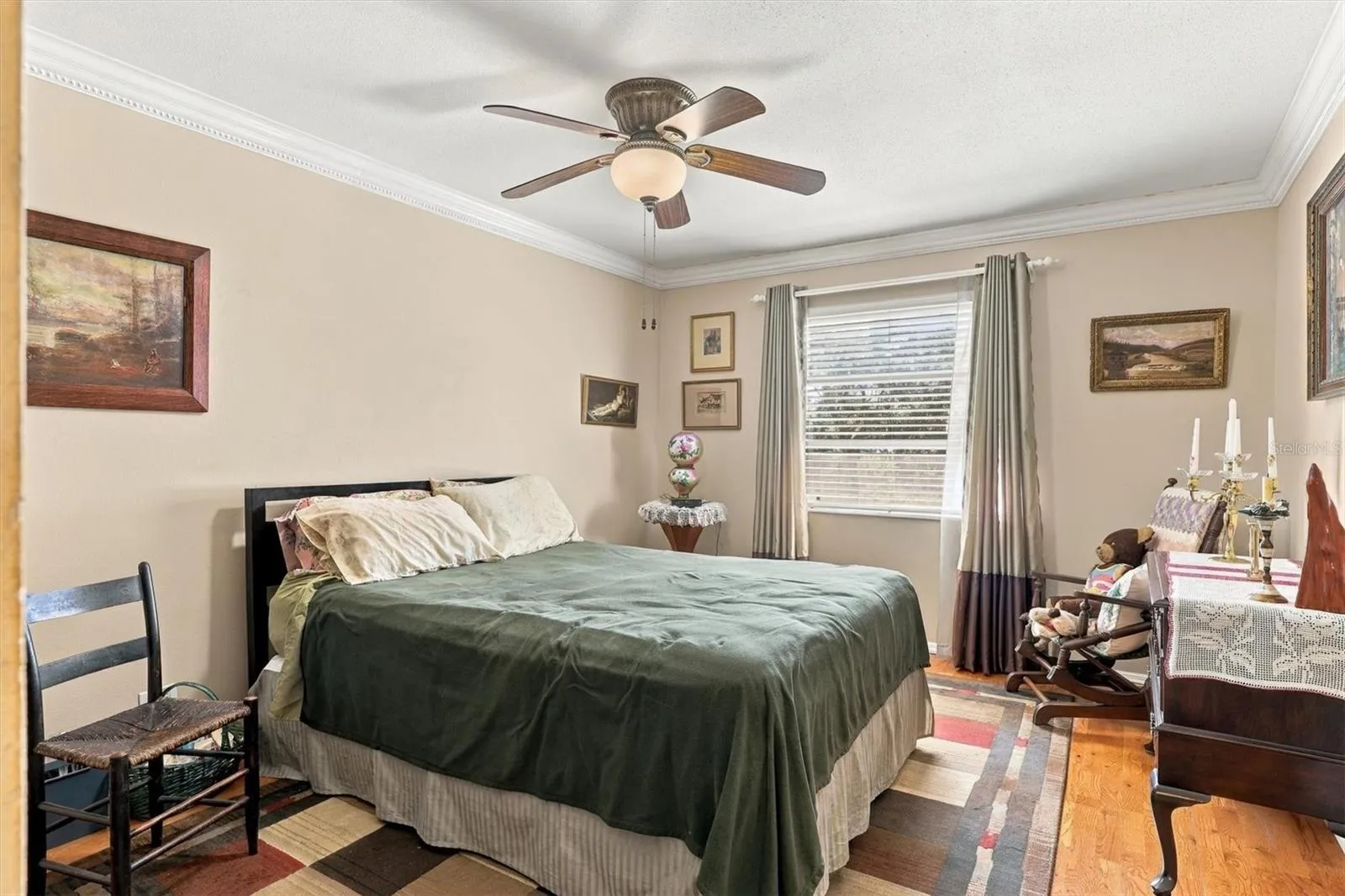 large bedroom with window and hard wood floors