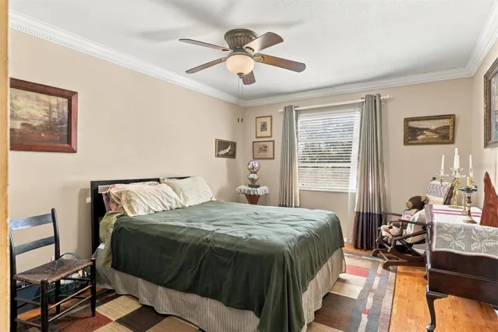 large bedroom with window and hard wood floors