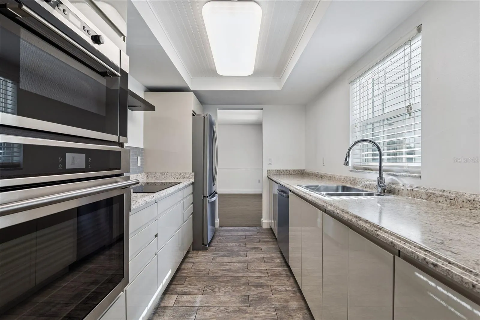 Kitchen with stainless double wall ovens and laminate counters