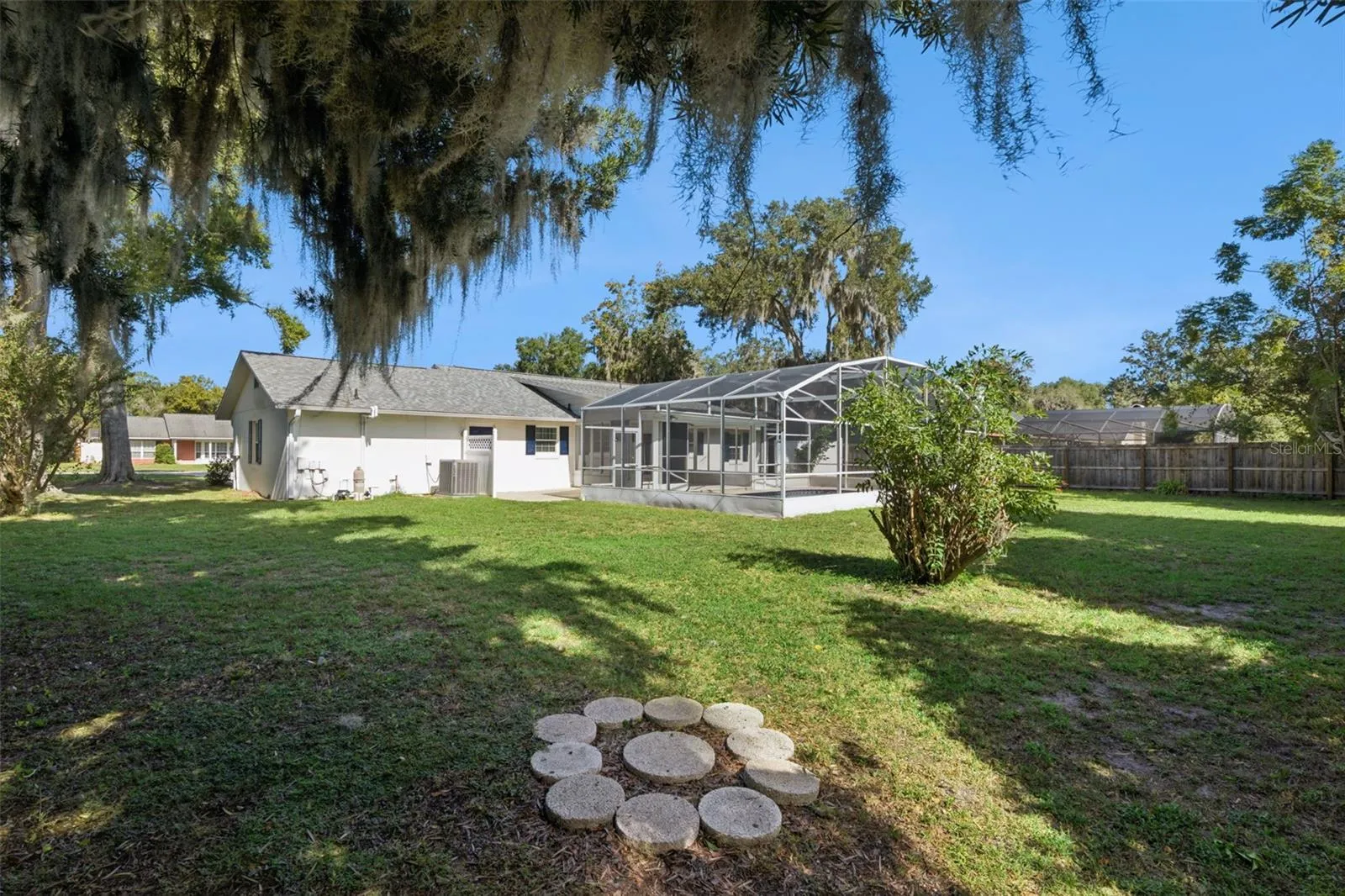 A huge backyard shaded by grand oaks